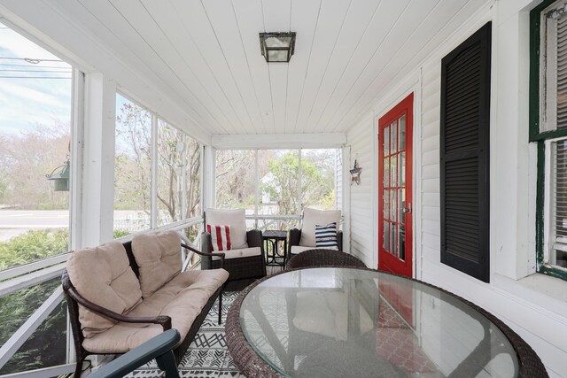 sunroom with plenty of natural light, french doors, and outdoor dining space