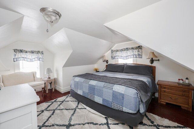bedroom featuring wood finished floors and lofted ceiling