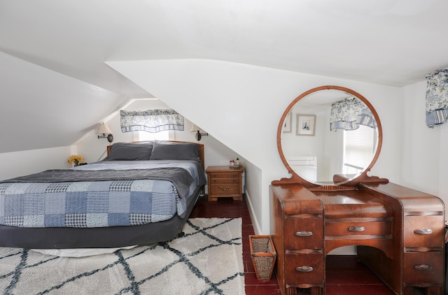 bedroom with vaulted ceiling and wood finished floors