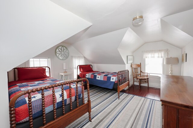 bedroom featuring multiple windows, lofted ceiling, and wood finished floors