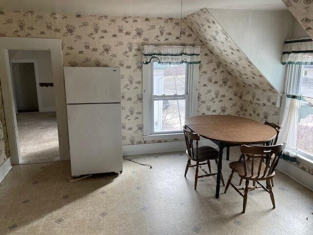 dining space featuring wallpapered walls