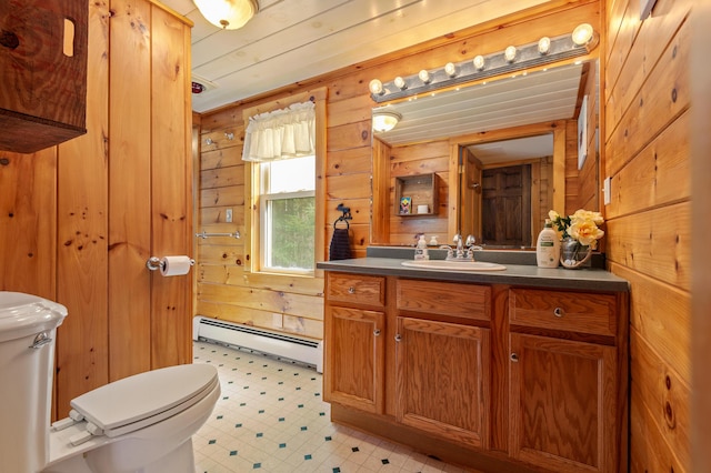 bathroom featuring wooden walls, vanity, toilet, tile patterned floors, and a baseboard heating unit