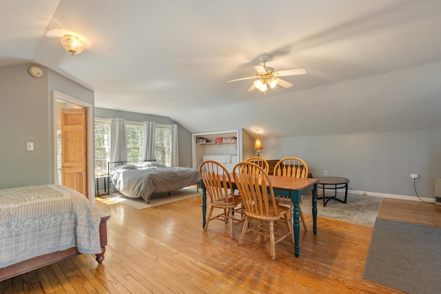 bedroom with wood-type flooring, a ceiling fan, baseboards, and vaulted ceiling