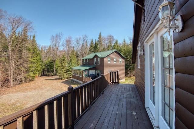 wooden terrace featuring a forest view