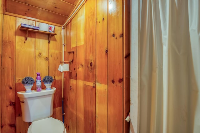 bathroom with wooden walls and toilet
