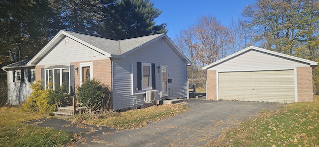 view of front of house with brick siding, an outbuilding, and a detached garage