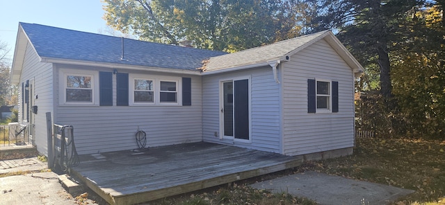 rear view of property with a shingled roof and a deck