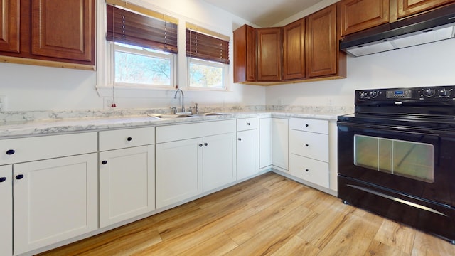 kitchen with electric range, a sink, white cabinetry, light wood-type flooring, and under cabinet range hood