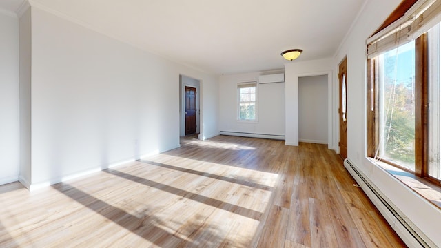 empty room with baseboard heating, light wood-type flooring, a baseboard heating unit, ornamental molding, and a wall mounted AC