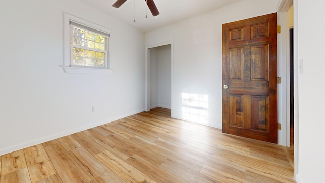 unfurnished bedroom with baseboards, light wood-style flooring, and ceiling fan