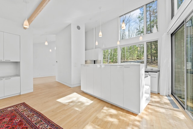 27 Carter Dr, West Bath, ME 04530 - interior space with modern cabinets, light wood-style floors, light countertops, white cabinets, and a high ceiling