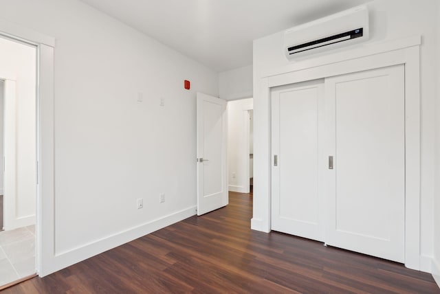 130 Morning St Unit 3A, Portland, ME 04101 - unfurnished bedroom featuring a wall mounted air conditioner, dark wood-style flooring, and a closet