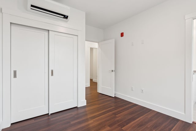130 Morning St Unit 3A, Portland, ME 04101 - unfurnished bedroom featuring a wall mounted AC, dark wood finished floors, and a closet