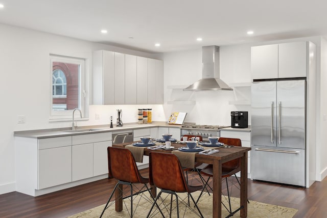 130 Morning St Unit 3A, Portland, ME 04101 - kitchen with appliances with stainless steel finishes, wall chimney range hood, dark wood-type flooring, white cabinetry, and recessed lighting