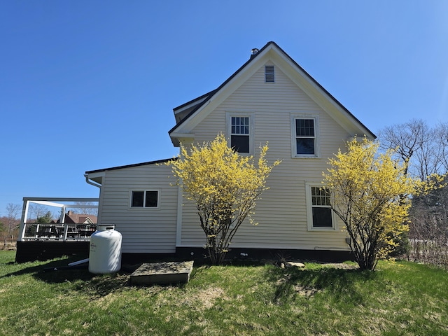 back of property with a yard and a wooden deck
