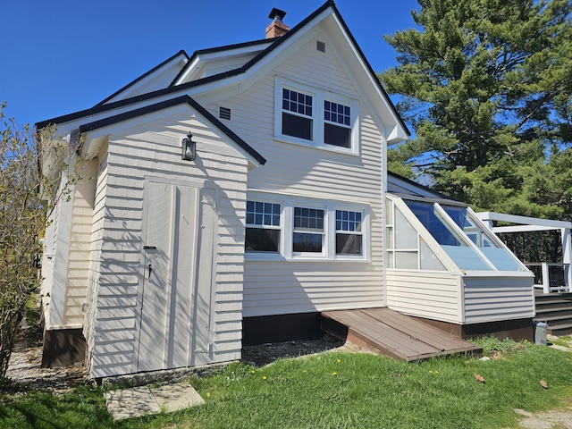 back of house with an outdoor structure and a chimney