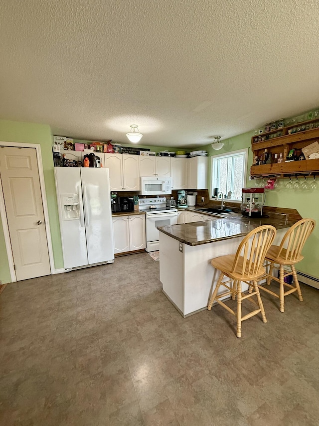 12 Grace Snow Dr, Glenburn, ME 04401 - kitchen featuring white appliances, a peninsula, a sink, white cabinetry, and dark countertops