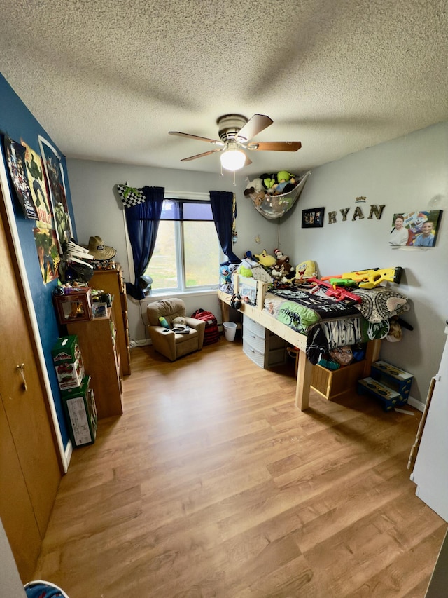 12 Grace Snow Dr, Glenburn, ME 04401 - bedroom with light wood-style floors, a textured ceiling, and a ceiling fan