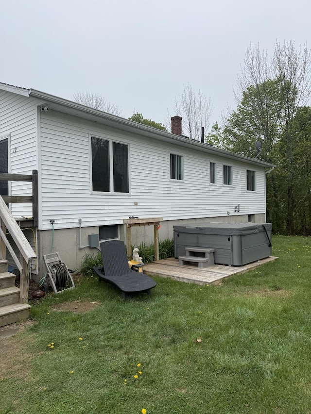12 Grace Snow Dr, Glenburn, ME 04401 - back of property featuring a hot tub, a lawn, and a chimney