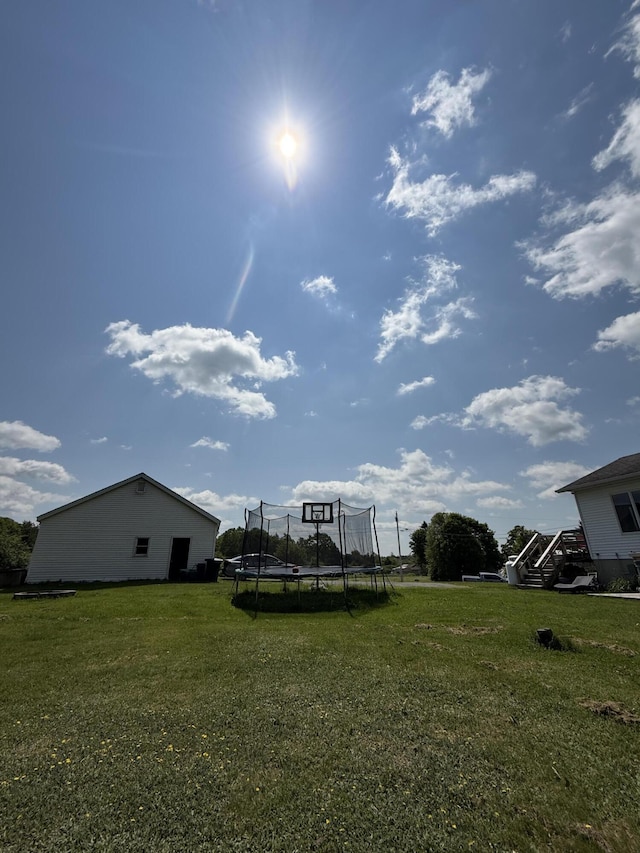 12 Grace Snow Dr, Glenburn, ME 04401 - view of green lawn with a trampoline and stairway