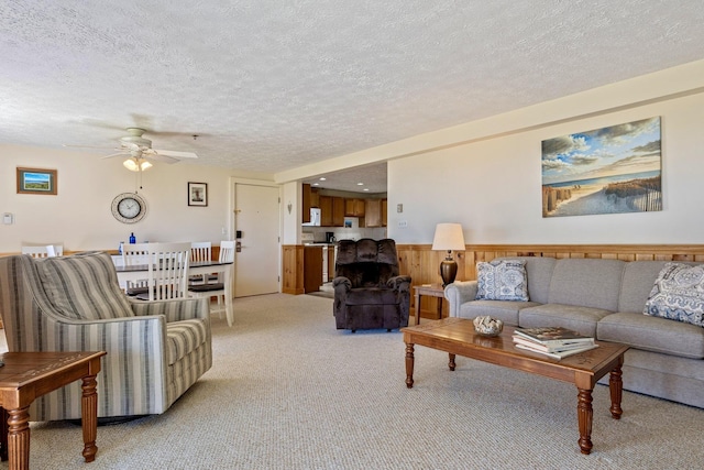 1373 Post Rd Unit 4A, Wells, ME 04090 - living room with a ceiling fan, a textured ceiling, light carpet, and a wainscoted wall