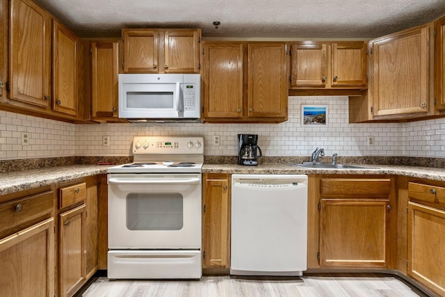 1373 Post Rd Unit 4A, Wells, ME 04090 - kitchen featuring brown cabinetry, a sink, decorative backsplash, and white appliances