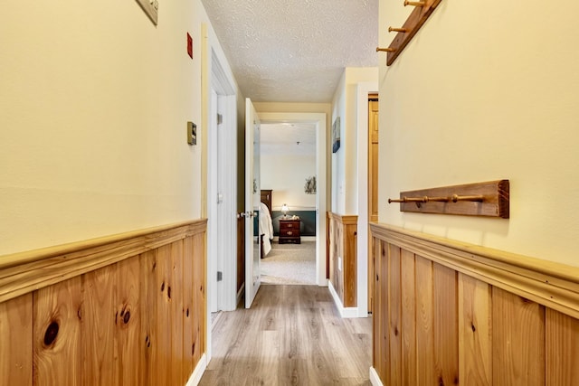 1373 Post Rd Unit 4A, Wells, ME 04090 - hallway with a wainscoted wall, light wood finished floors, and a textured ceiling