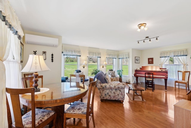 61 Pond Rd, Albion, ME 04910 - dining room featuring an AC wall unit, wood finished floors, and a wealth of natural light