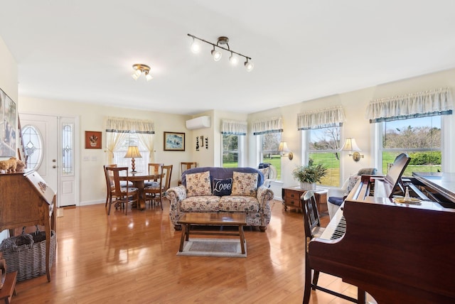 61 Pond Rd, Albion, ME 04910 - living room with baseboards, a wall unit AC, a wealth of natural light, and light wood-style floors