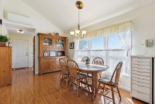 61 Pond Rd, Albion, ME 04910 - dining space featuring baseboards, high vaulted ceiling, a wall mounted AC, light wood finished floors, and a notable chandelier