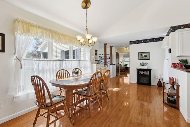 61 Pond Rd, Albion, ME 04910 - dining area with a fireplace, a notable chandelier, lofted ceiling, ornate columns, and light wood-style flooring