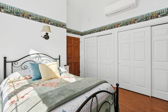 61 Pond Rd, Albion, ME 04910 - bedroom featuring two closets, a wall unit AC, wood finished floors, and a towering ceiling