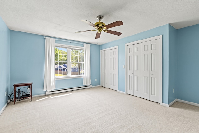 161 Saco Ave Unit 404, Old Orchard Beach, ME 04064 - unfurnished bedroom with a baseboard radiator, carpet, multiple closets, a textured ceiling, and baseboards