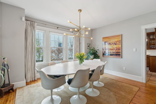 14 Codman St, Portland, ME 04103 - dining space featuring a chandelier, light wood-style flooring, and baseboards