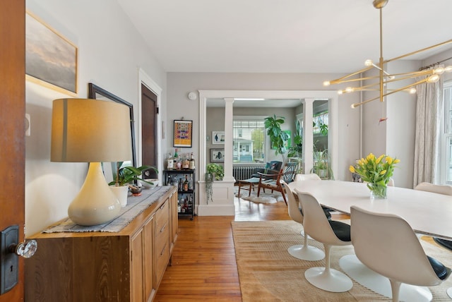 14 Codman St, Portland, ME 04103 - dining room with light wood finished floors, ornate columns, and a chandelier