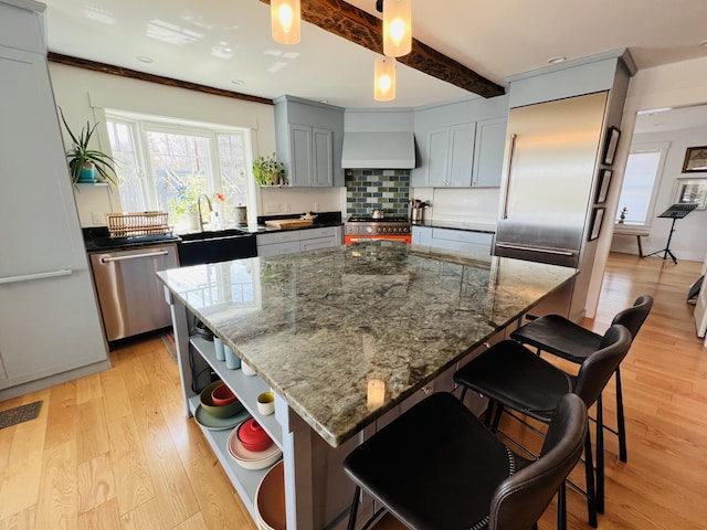 157 Ellsworth Rd, Blue Hill, ME 04614 - kitchen featuring custom exhaust hood, appliances with stainless steel finishes, open shelves, light wood-style flooring, and gray cabinetry