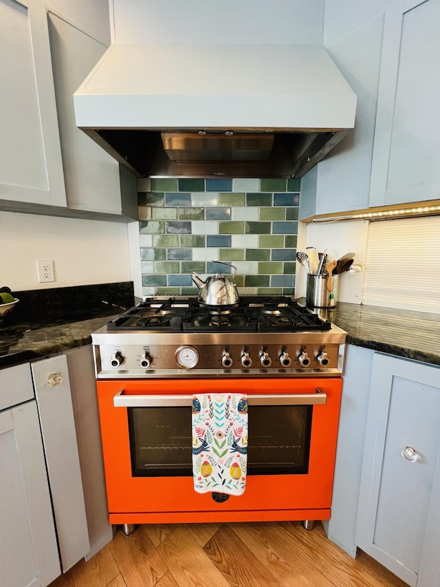 157 Ellsworth Rd, Blue Hill, ME 04614 - kitchen with gas range, wall chimney range hood, backsplash, and light wood finished floors
