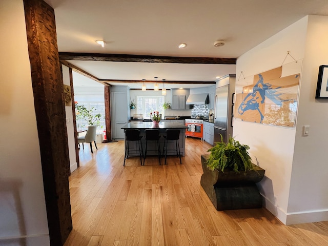 157 Ellsworth Rd, Blue Hill, ME 04614 - kitchen featuring stainless steel range, a kitchen bar, light wood-style flooring, dark countertops, and beam ceiling