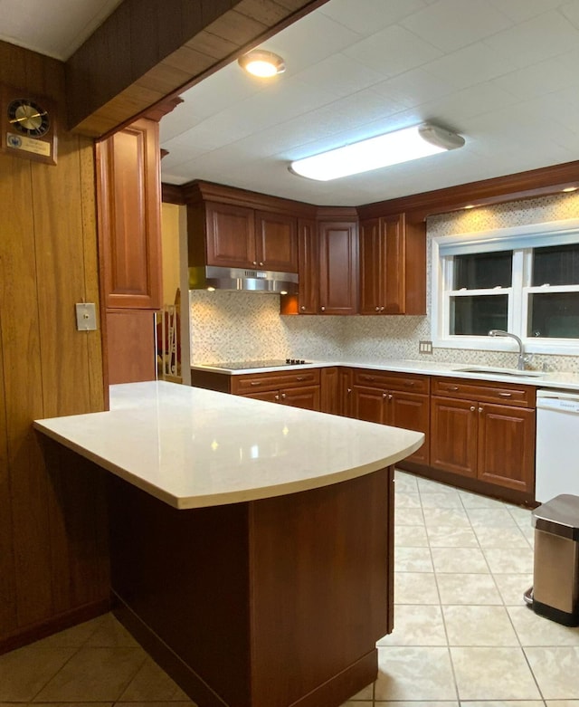 kitchen with a sink, light countertops, backsplash, and black electric stovetop