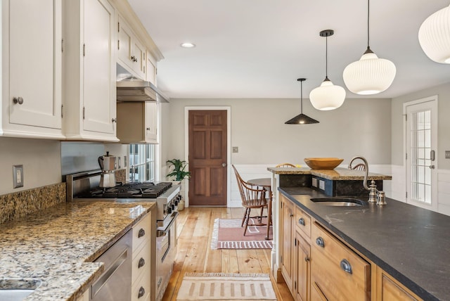 26 Hunts Point Rd, Cape Elizabeth, ME 04107 - kitchen featuring a sink, stainless steel appliances, dark stone counters, under cabinet range hood, and light wood-type flooring