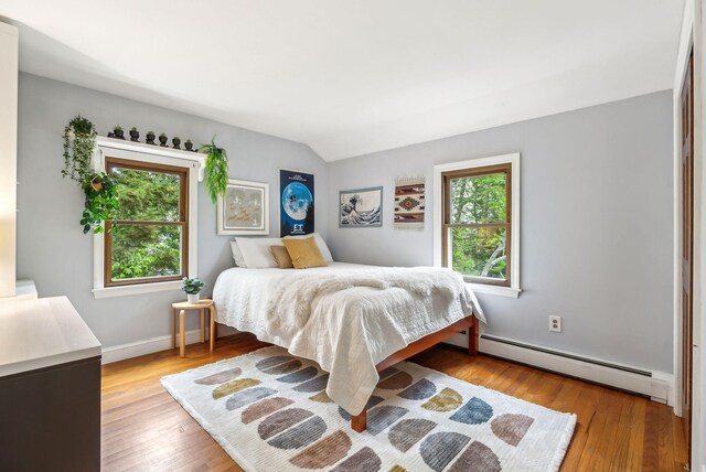 26 Hunts Point Rd, Cape Elizabeth, ME 04107 - bedroom featuring a baseboard heating unit, wood finished floors, vaulted ceiling, and baseboards