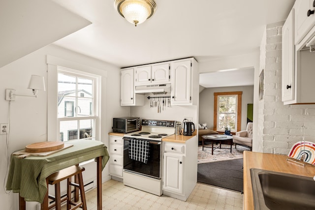 47 Bay View St, Camden, ME 04843 - kitchen featuring electric range, under cabinet range hood, a sink, light flooring, and white cabinetry