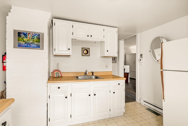 47 Bay View St, Camden, ME 04843 - kitchen with freestanding refrigerator, a sink, light floors, white cabinets, and light countertops
