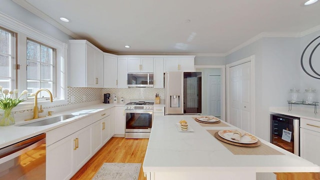 12 Summit Ter, Falmouth, ME 04105 - kitchen with a kitchen island, appliances with stainless steel finishes, tasteful backsplash, a sink, and light wood-style flooring