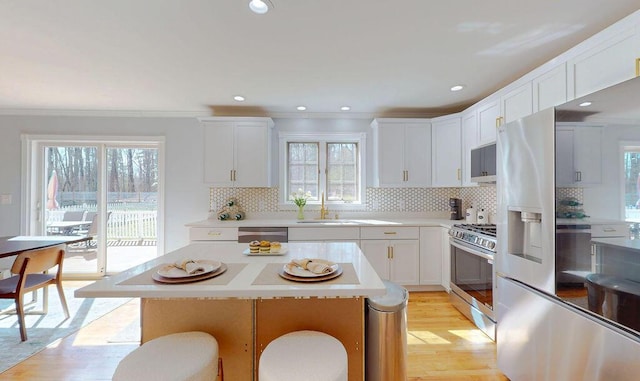 12 Summit Ter, Falmouth, ME 04105 - kitchen with a sink, stainless steel appliances, white cabinetry, and a wealth of natural light