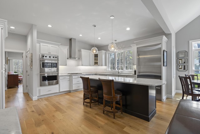 3 Flagship Cir, Kennebunk, ME 04043 - kitchen featuring stainless steel appliances, wall chimney range hood, white cabinets, plenty of natural light, and recessed lighting