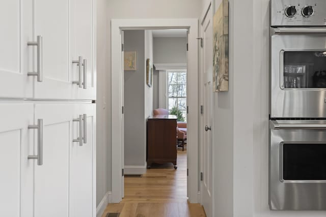 3 Flagship Cir, Kennebunk, ME 04043 - kitchen featuring stainless steel double oven, light wood finished floors, white cabinetry, and baseboards