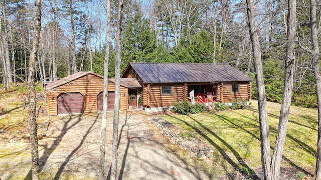 370 Point Rd, Belgrade, ME 04917 - view of front of home featuring an attached garage, log exterior, a front yard, driveway, and metal roof