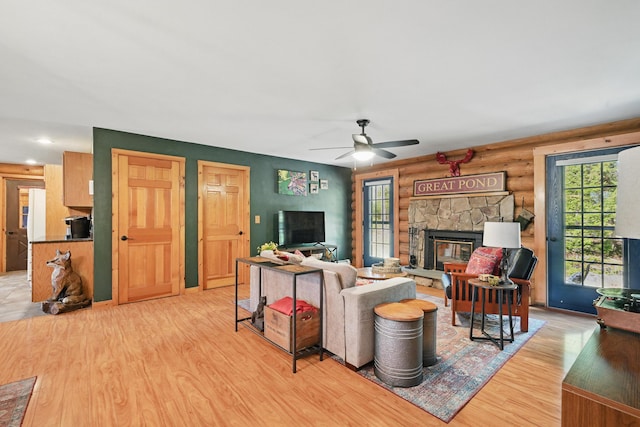 370 Point Rd, Belgrade, ME 04917 - living room with a ceiling fan, log walls, wood finished floors, and a fireplace