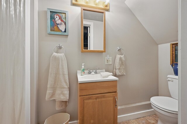 370 Point Rd, Belgrade, ME 04917 - bathroom with wood finished floors, vanity, baseboards, toilet, and lofted ceiling